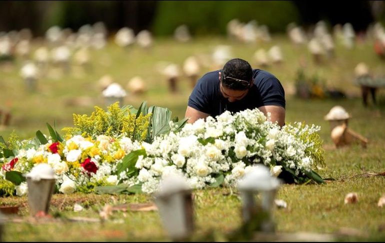 Un hombre visita una tumba en el cementerio Campo de Esperanza, en Brasilia. EFE/J. Alves
