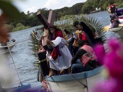 Decenas de personas ataviadas con tradicionales vestimentas católicas llenan de color las aguas del lago en esta solemnidad religiosa. EFE/J. Torres