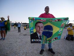 Seguidores del presidente de Brasil, Jair Bolsonaro, rezan durante una protesta contra el cierre comercial debido a la pandemia de coronavirus, en Brasilia. EFE/J. Alves