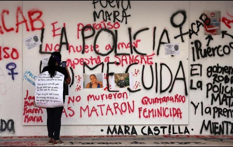 Una mujer toma una fotografía con su celular de una instalación hecha en honor a la migrante salvadoreña Victoria Salazar, asesinada por policías en Tulum, Quintana Roo. EFE/A. Cupul