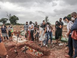 Familiares lloran la muerte por COVID-19 de un ser querido durante su entierro este martes, en un cementerio del norte de Río de Janeiro. EFE/A. Coelho