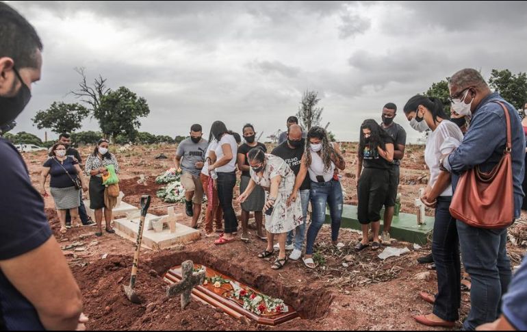Familiares lloran la muerte por COVID-19 de un ser querido durante su entierro este martes, en un cementerio del norte de Río de Janeiro. EFE/A. Coelho