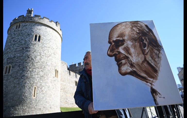 Un artista sostiene una pintura del rostro del difunto príncipe frente al castillo de Windsor, en Gran Bretaña. EFE / N. Hall