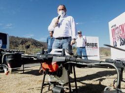 El morenista muestra el sistema de aspersores de un dron, con el que dice se pueden sembrar semillas de encino y pino en unos minutos. ESPECIAL