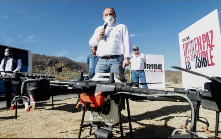 El morenista muestra el sistema de aspersores de un dron, con el que dice se pueden sembrar semillas de encino y pino en unos minutos. ESPECIAL
