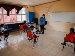Los menores son sanitizados al acceso de la escuela y en cada salón de clases no pueden estar más de cuatro alumnos. AP/M. Zetina