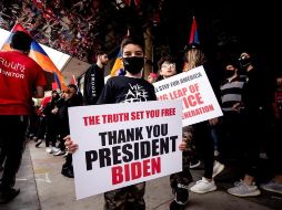 Un manifestante sostiene un cartel que dice 