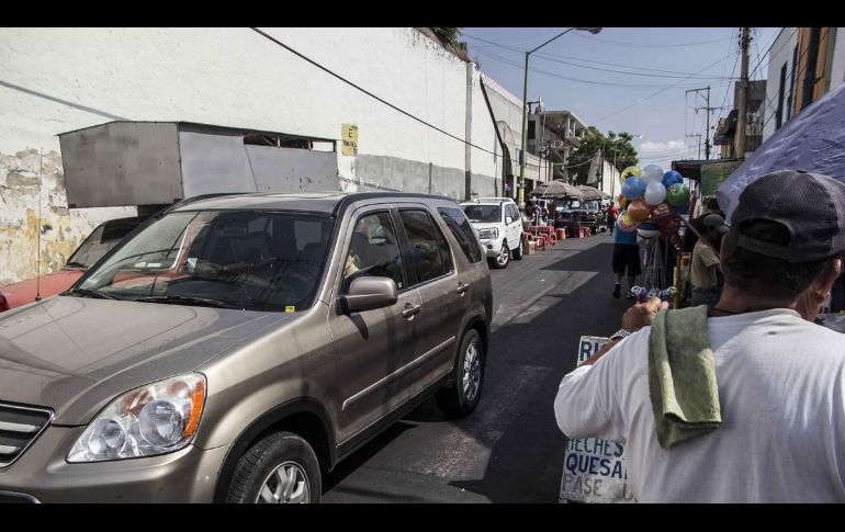 Los apartalugares llegan desde temprano a esperar a los automovilistas en el cruce de 16 de septiembre y calzada del Campesino. EL INFORMADOR/Archivo