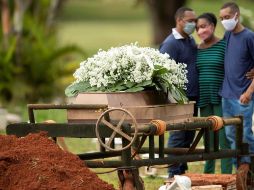 Un grupo de personas asiste al entierro de un ser querido víctima de COVID-19 en el cementerio Campo da Esperança, en la ciudad de Brasilia. EFE/J. Alves