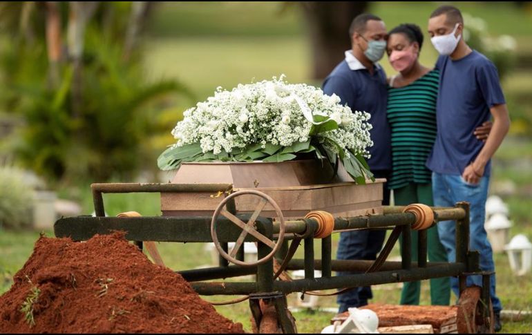 Un grupo de personas asiste al entierro de un ser querido víctima de COVID-19 en el cementerio Campo da Esperança, en la ciudad de Brasilia. EFE/J. Alves