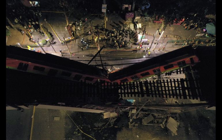 Una trabe se desplomó justo cuando pasaba un tren el Metro y un automóvil quedó aplastado debajo. AFP/P. Pardo