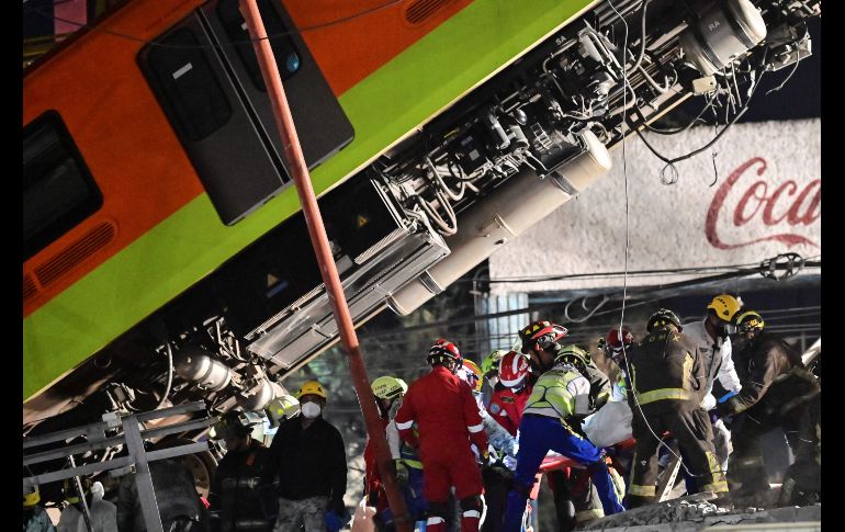 Rescatistas trasladan un cuerpo tras sacarlo del vagón. AFP/P. Pardo