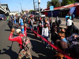 Usuarios del Metro hacen largas filas para abordar autobuses durante los trabajos del retiro de un vagón que colapsó este lunes en la noche. EFE/C. Ramírez