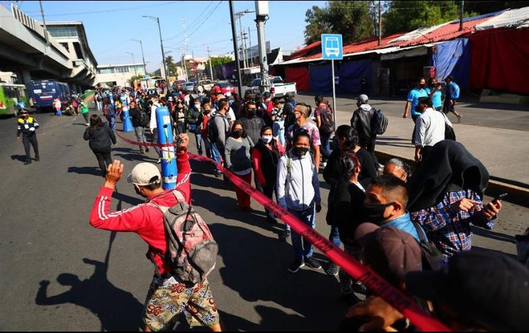 Usuarios del Metro hacen largas filas para abordar autobuses durante los trabajos del retiro de un vagón que colapsó este lunes en la noche. EFE/C. Ramírez