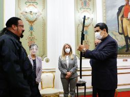 Vestido de negro y con el rostro al descubierto, Steven Seagal, especialista en artes marciales, entregó la “katana” a Maduro. EFE / P. Miraflores