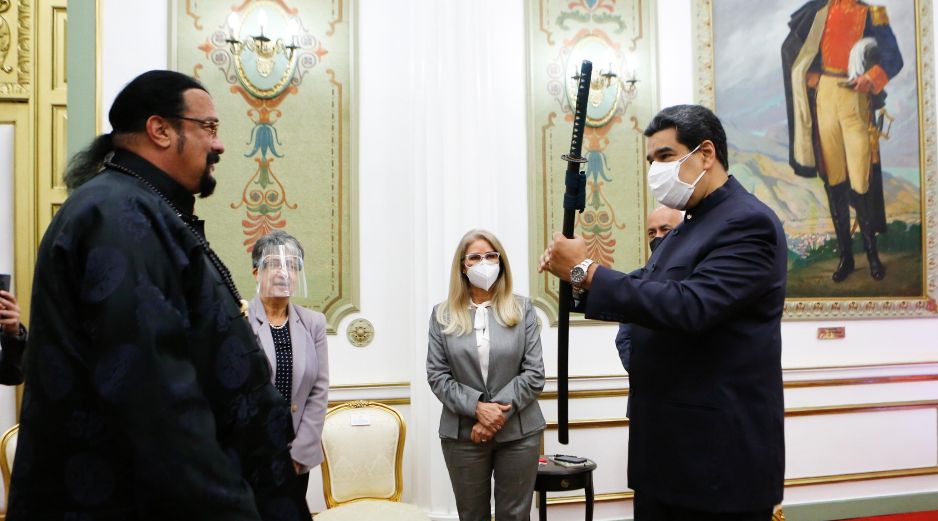 Vestido de negro y con el rostro al descubierto, Steven Seagal, especialista en artes marciales, entregó la “katana” a Maduro. EFE / P. Miraflores