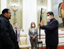 Vestido de negro y con el rostro al descubierto, Steven Seagal, especialista en artes marciales, entregó la “katana” a Maduro. EFE / P. Miraflores