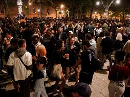 Personas celebran junto al Passeig de Lluis Companys, en Barcelona, el fin del estado de alarma en España durante la madrugada del domingo. EFE/Q. Garcia