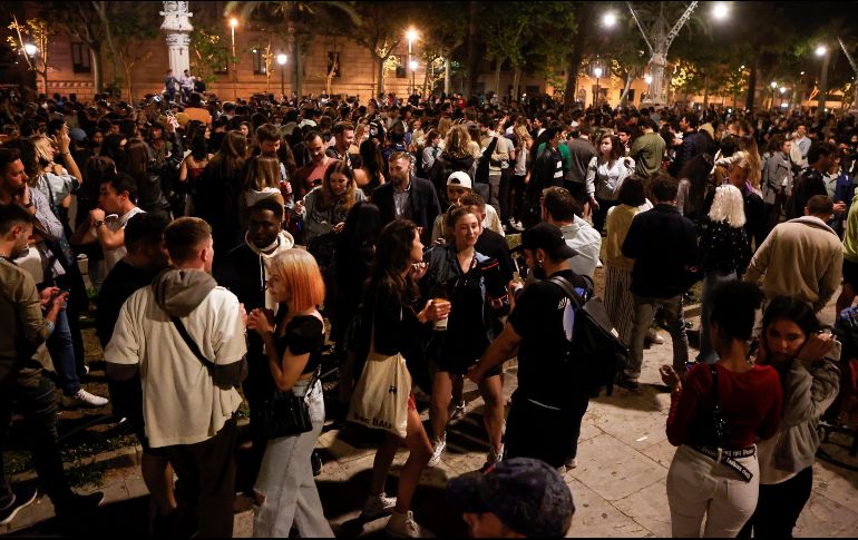 Personas celebran junto al Passeig de Lluis Companys, en Barcelona, el fin del estado de alarma en España durante la madrugada del domingo. EFE/Q. Garcia