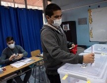 Dante Davagnino (i), uno de los mutilados oculares a manos de la policía durante las manifestaciones que agitaron Chile en octubre de 2019, vota en Santiago. EFE/A. Valdés