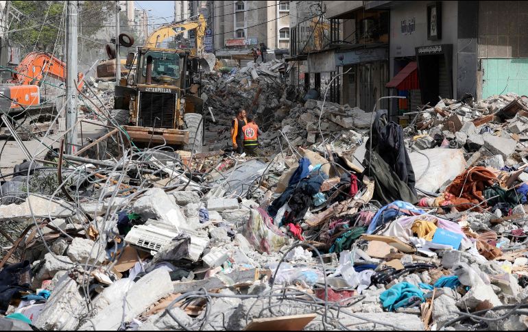 Una máquina excavadora retira hoy escombros de un edificio destruido en la Ciudad de Gaza, luego de un bombardeo de Israel. AFP/M. Hams