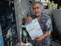 Miguel Ortiz muestra el recibo de su pago anual al SIAPA. EL INFORMADOR/G. Gallo