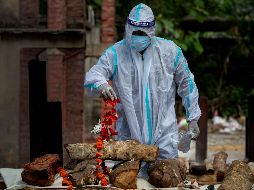 Una persona realiza los rituales cerca del cuerpo de un familiar fallecido por COVID-19, durante una cremación en Gauhati, India. AP/A. Nath
