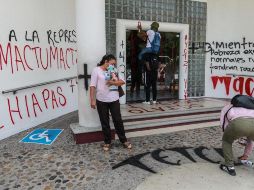 Varias personas pintan mensajes en el Palacio federal durante unas protestas hoy, en Acapulco, para exigir la liberación de los normalistas de Mactumatzá. EFE/D. Guzmán