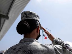 Una integrante de la Guardia Nacional hace hoy el saludo a la bandera, durante la ceremonia de inauguración de un cuartel en Rosarito, Baja California. AFP/G. Arias