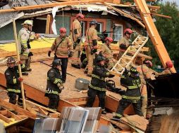 Bomberos usan sierras y otras herramientas para tratar de excavar entre los escombros. AFP/C. Somodevilla