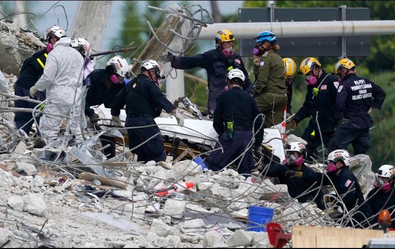 Rescatistas trasladan un cuerpo hallado hoy entre los escombros del edificio en Surfsine. AP/L. SladkySladky