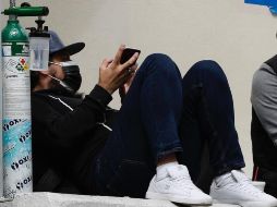 Un hombre espera junto a un tanque de oxígeno informes de sus familiares contagiados de COVID-19, en la zona de emergencias del hospital Los Venados, en la Ciudad de México. EFE/ARCHIVO