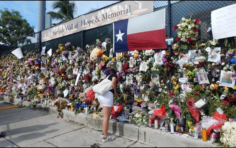 Varias personas visitan una valla dedicada a los desaparecidos en el derrumbe del edificio de condominios en Surfside, Florida. EFE/L. Kassidi