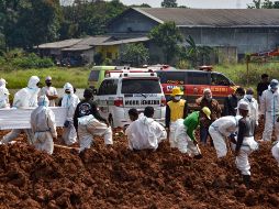 Trabajadores entirran hoy cuerpos de víctimas de COVID-19 en un cementerio público en Bekasi, Indonesia. AFP/Rezas