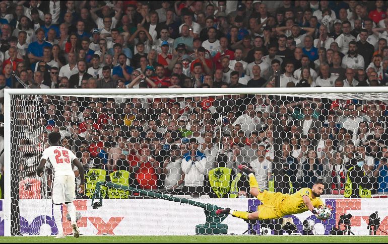 EL MOMENTO. Gianluigi Donnarumma ataja el disparo de Bukayo Saka para que los italianos levantaran el cetro del Viejo Continente. AFP