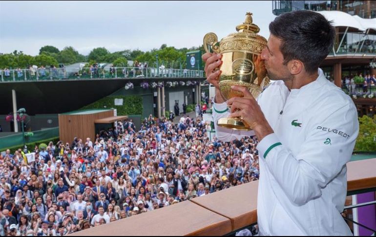 El serbio Novak Djokovic besa este domingo el trofeo que le acredita como ganador del Wimbledon 2021. EFE/B. Martin