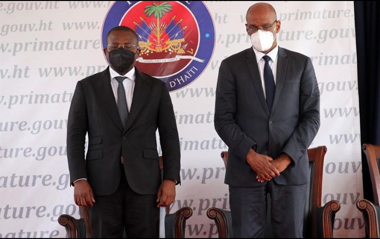El nuevo primer ministro, Ariel Henry (d), y su antecesor, Claude Joseph, guardan un minuto de silencio durante la ceremonia de toma de posesión del nuevo Gobierno haitiano. EFE/O. Barría