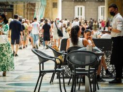 Un camarero atiende a los clientes en la terraza de un restaurante en Nápoles, Italia. EFE/C. Abbate