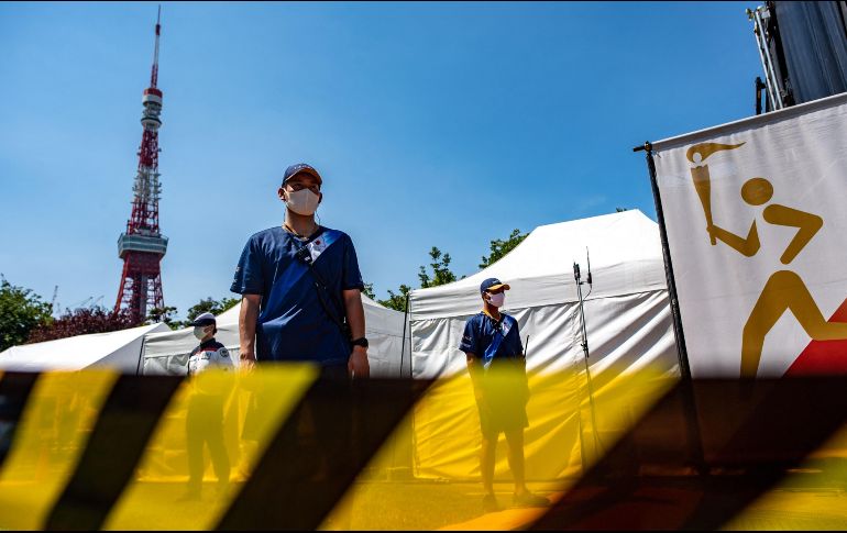 Policías resguardan la antorcha olímpica, antes de la inauguración de Tokio 2020. AFP / P. Fong