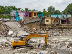 Autoridades locales utilizan maquinaria pesada para remover los restos de casas afectadas por los deslaves en Dharmsala, en India. AP/A. Bathia