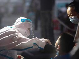 PRUEBAS. Un trabajador médico toma una muestra de hisopado de un residente para una prueba de ácido nucleico de COVID-19, en Wuhan, en China. La ciudad lanzó el martes una nueva ronda de pruebas para detectar contagios entre su población. XINHUA