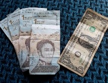 En Venezuela, el efectivo escasea y es usual ver largas filas en los bancos. Así, el bolívar terminó siendo sustituido por el dólar, que se ha convertido en la moneda de facto en el país. EFE / R. Peña