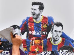 Un trabajador quita un cartel de Liones Messi en el Nou Camp, en Barcelona. AFP/P. Barrena