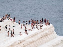 Personas buscar refrescarse con la brisa marina en la Scala dei Turchi, un acantilado rocoso en la costa de f Realmonte, en Sicilia. A/S. Cavalli