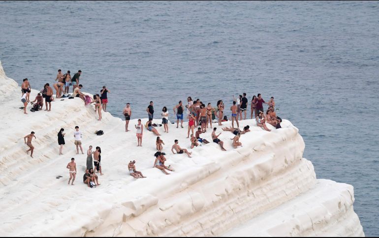 Personas buscar refrescarse con la brisa marina en la Scala dei Turchi, un acantilado rocoso en la costa de f Realmonte, en Sicilia. A/S. Cavalli