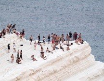 Personas buscar refrescarse con la brisa marina en la Scala dei Turchi, un acantilado rocoso en la costa de f Realmonte, en Sicilia. A/S. Cavalli