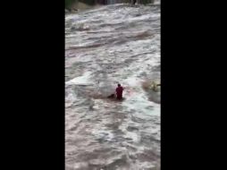 Una usuaria en redes sociales grabó el momento en que un joven rescató a una mujer que quedó en medio de un arroyo en Baja California Sur. YOUTUBE / Extasis Mazatlan