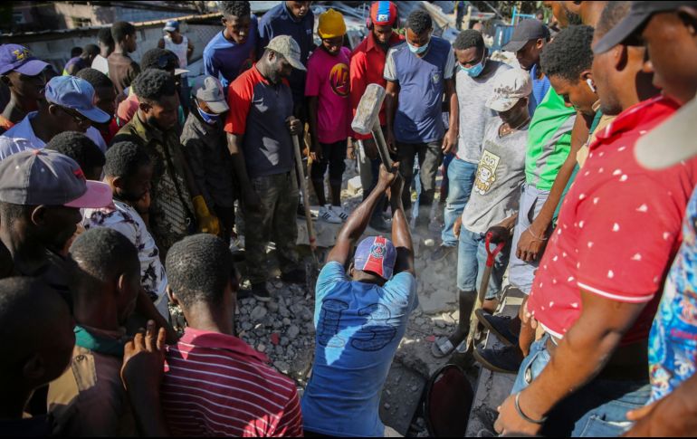 Civiles luchan para sacar a personas de los escombros.  AP/J. Odelyn