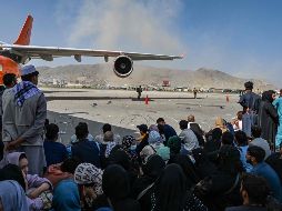 Afganos permanecen en el aeropuerto de Kabul. AFP / W. Kohsar