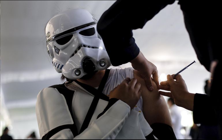 Una mujer disfrazada recibe hoy una vacuna contra el COVID-19, en la Ciudad de México. En el país se ha administradon 79.39 millones de dosis de la vacuna. Xinhua/F. Cañedo